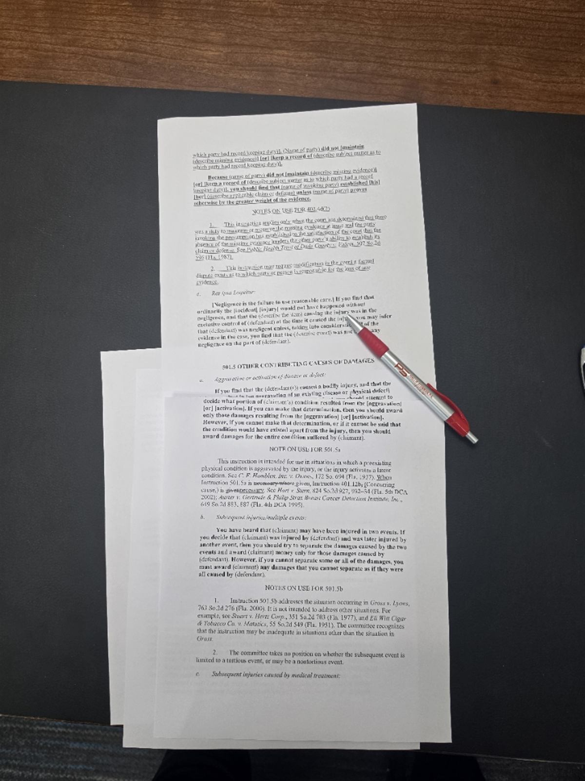 Printed pages of Florida Standard Jury Instruction 501.5 on aggravation of a pre-existing condition, spread on a desk with a pen on top